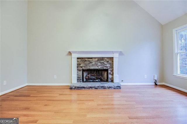 402 Hancock Ct, Woodstock, GA 30188 - unfurnished living room with high vaulted ceiling, wood finished floors, plenty of natural light, and a stone fireplace