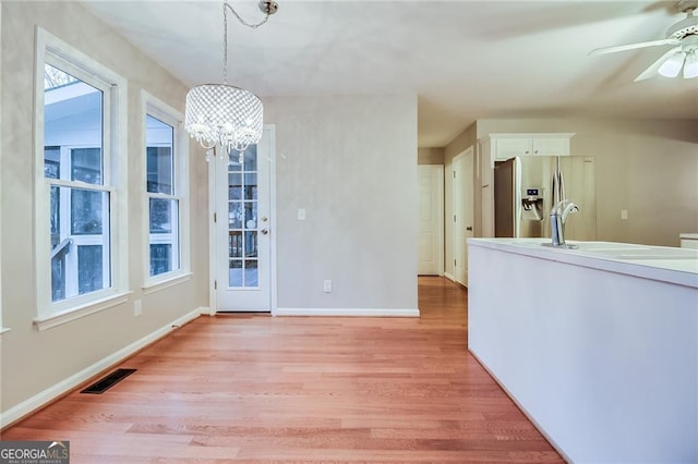 402 Hancock Ct, Woodstock, GA 30188 - unfurnished dining area with light wood-style floors, ceiling fan, a chandelier, and healthy amount of natural light