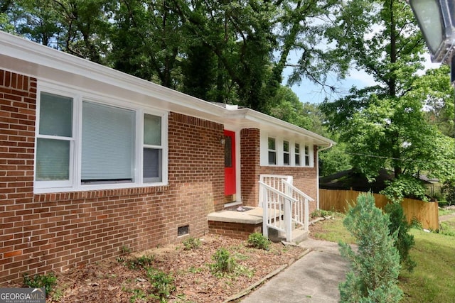 579 Kenridge Cir, Stone Mountain, GA 30083 - view of exterior entry with brick siding, fence, and crawl space