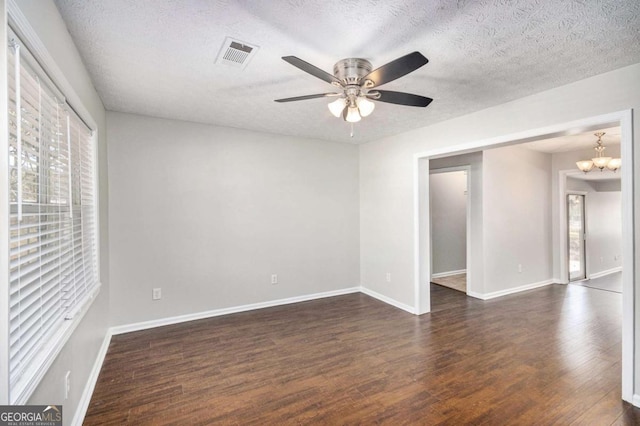1602 Sycamore Dr NW, Kennesaw, GA 30152 - empty room with dark wood-type flooring, ceiling fan, baseboards, a textured ceiling, and a chandelier