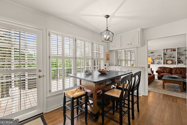 dining area with wood finished floors and ornamental molding