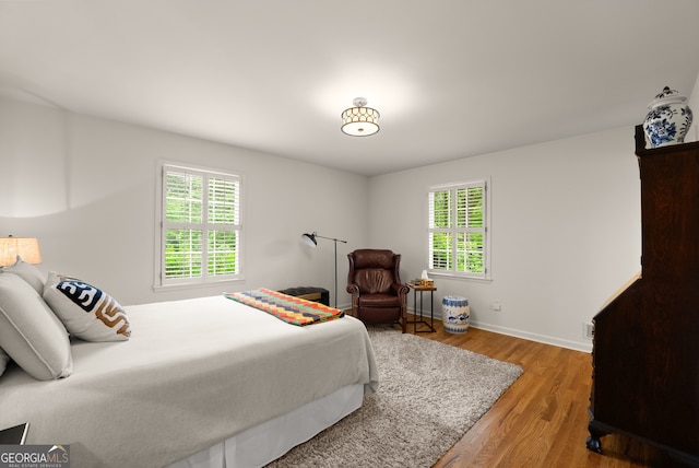 bedroom with wood finished floors and baseboards