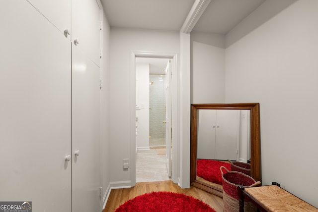 hall with light wood finished floors and baseboards