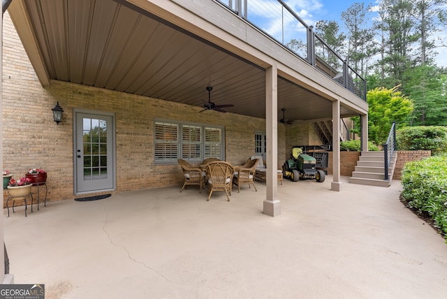view of patio / terrace featuring stairs, a ceiling fan, outdoor dining area, and a balcony