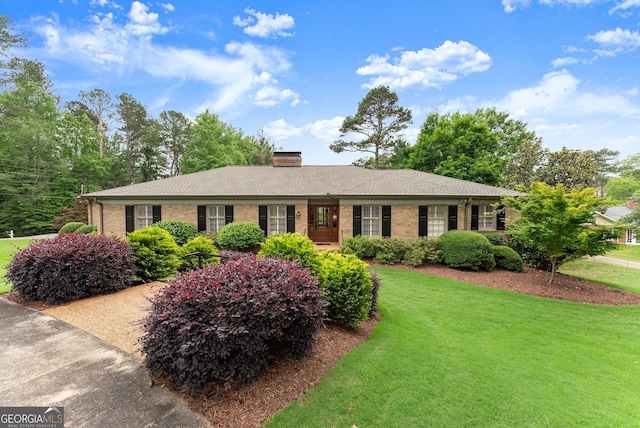 ranch-style house featuring a front yard, brick siding, and a chimney