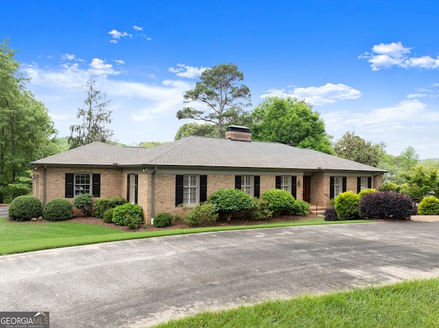 ranch-style house with brick siding and a chimney