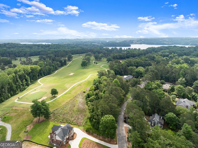 aerial view of property and surrounding area with a local golf course, a large body of water, and a forest