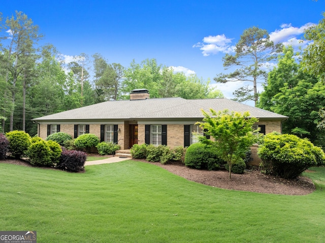 ranch-style home featuring a front lawn, brick siding, and a chimney