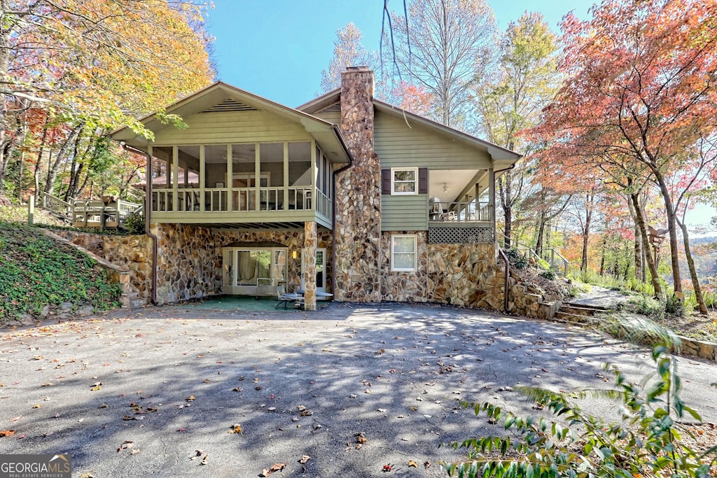 445 Joe Davis Rd, Tiger, GA 30576 - rear view of property featuring a sunroom, a chimney, a carport, driveway, and stone siding