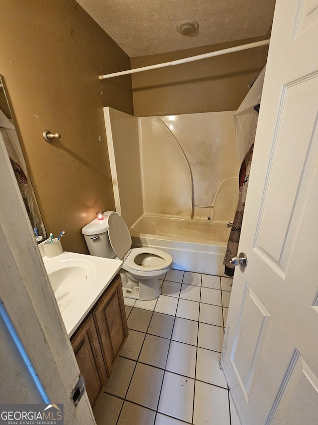 full bath featuring tile patterned flooring, bathtub / shower combination, toilet, vanity, and a textured ceiling