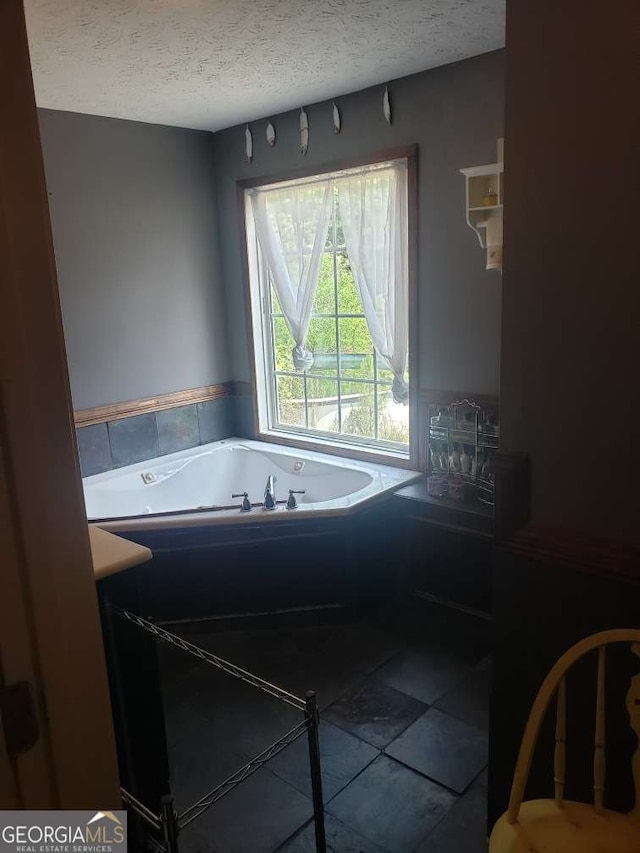 1383 Sims Rd SE, Winder, GA 30680 - bathroom featuring a textured ceiling, a whirlpool tub, and tile patterned flooring