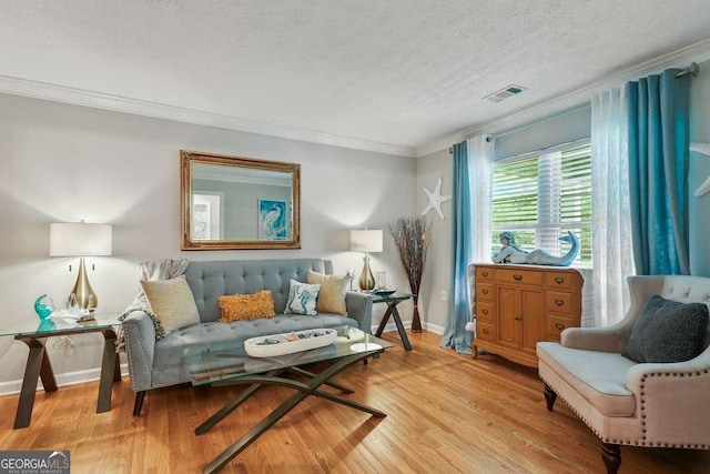 living area with crown molding, wood finished floors, a textured ceiling, and baseboards