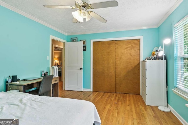 bedroom featuring a textured ceiling, wood finished floors, crown molding, ceiling fan, and baseboards