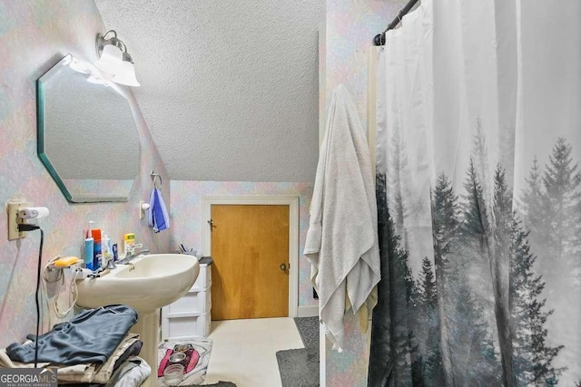 full bath featuring a textured ceiling, curtained shower, and vaulted ceiling