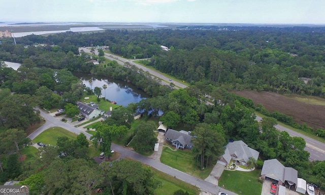 view of property location featuring a large body of water and a heavily wooded area