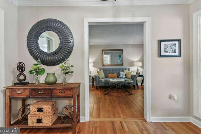 corridor featuring baseboards, wood finished floors, and ornamental molding