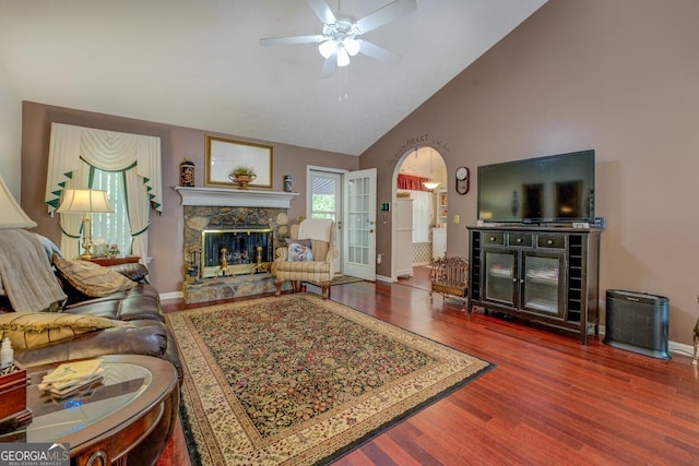 3870 Michaels Creek Ct, Loganville, GA 30052 - living area with a stone fireplace, ceiling fan, wood finished floors, baseboards, and high vaulted ceiling