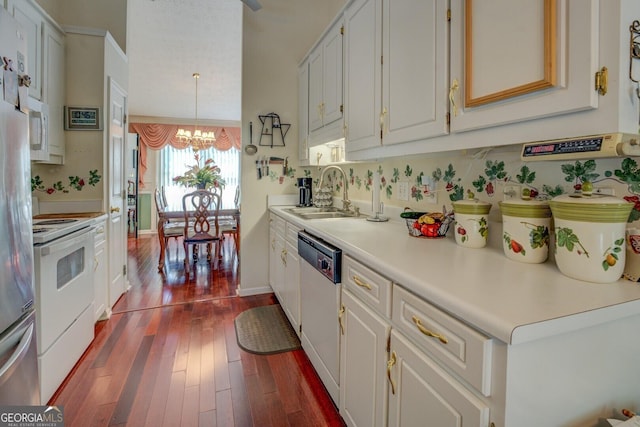 3870 Michaels Creek Ct, Loganville, GA 30052 - kitchen featuring a sink, white appliances, a chandelier, dark wood finished floors, and light countertops