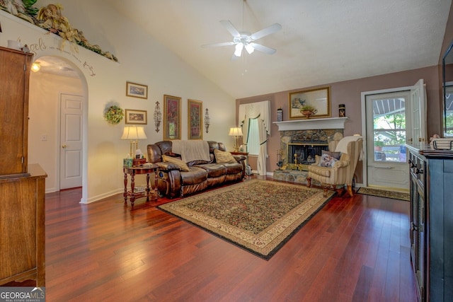3870 Michaels Creek Ct, Loganville, GA 30052 - living area with ceiling fan, dark wood-type flooring, arched walkways, a fireplace, and high vaulted ceiling
