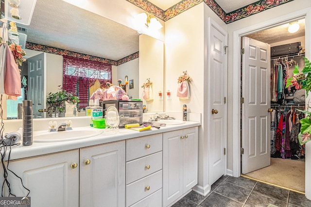 643 Lora Smith Rd, Newnan, GA 30265 - bathroom with double vanity, a textured ceiling, a spacious closet, and tile patterned flooring