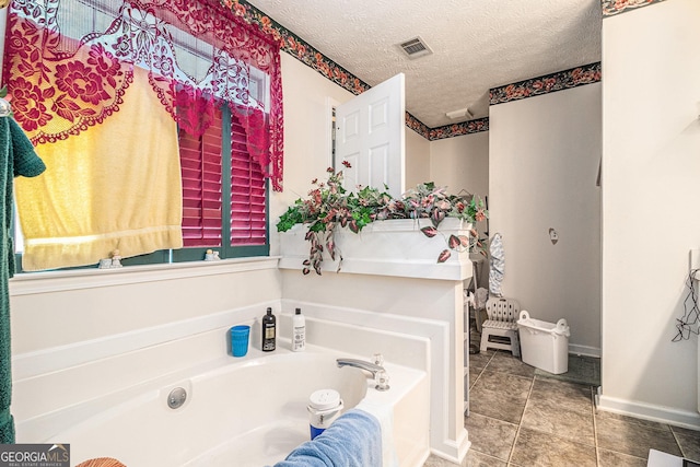 643 Lora Smith Rd, Newnan, GA 30265 - bathroom with a bath, a textured ceiling, tile patterned flooring, and baseboards