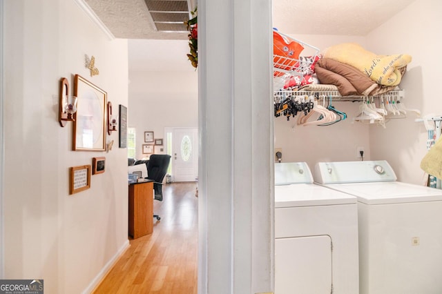 643 Lora Smith Rd, Newnan, GA 30265 - washroom featuring separate washer and dryer, light wood-style floors, a textured ceiling, and baseboards