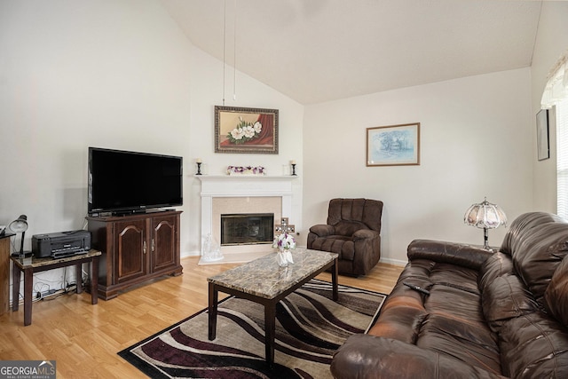 643 Lora Smith Rd, Newnan, GA 30265 - living area with vaulted ceiling, light wood-style floors, a high end fireplace, and baseboards