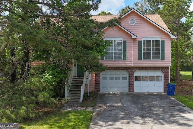 view of front of property with a garage, driveway, brick siding, and roof with shingles