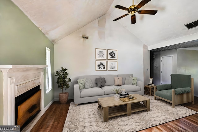 living area featuring high vaulted ceiling, a ceiling fan, wood finished floors, a fireplace, and baseboards