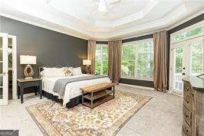 415 Morgan Falls Chase, Canton, GA 30114 - bedroom featuring crown molding, access to outside, multiple windows, a tray ceiling, and ceiling fan