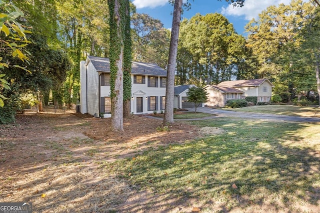4045 White Oak Ln SW, Lilburn, GA 30047 - colonial-style house featuring a front lawn and view of scattered trees