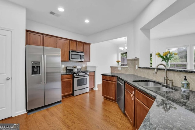 1929 Brightleaf Way, Marietta, GA 30060 - kitchen with appliances with stainless steel finishes, dark stone countertops, light wood-style flooring, backsplash, and recessed lighting
