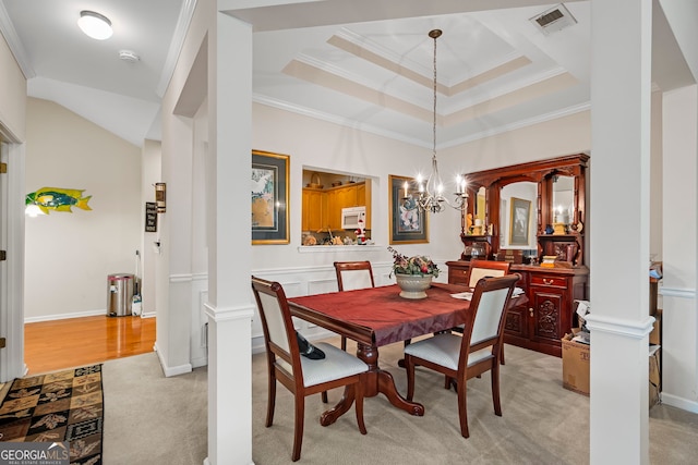 dining area with ornamental molding, light colored carpet, a chandelier, and ornate columns