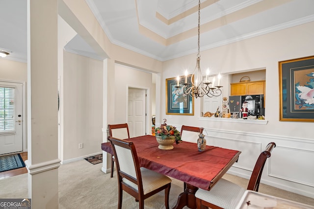 dining area featuring ornamental molding, light carpet, a chandelier, and a raised ceiling