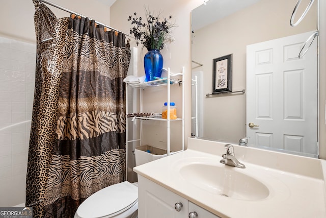 bathroom featuring toilet, vanity, and a shower with curtain