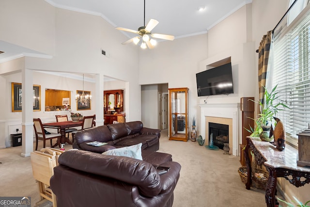 living area with light colored carpet, a fireplace with flush hearth, ceiling fan, crown molding, and a chandelier