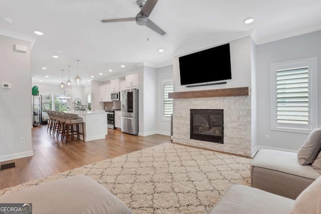 1768 Evenstad Way, Smyrna, GA 30080 - living room featuring a ceiling fan, plenty of natural light, crown molding, baseboards, and light wood finished floors