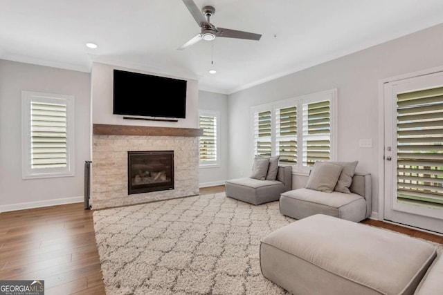 1768 Evenstad Way, Smyrna, GA 30080 - living room featuring wood finished floors, ceiling fan, baseboards, a glass covered fireplace, and crown molding
