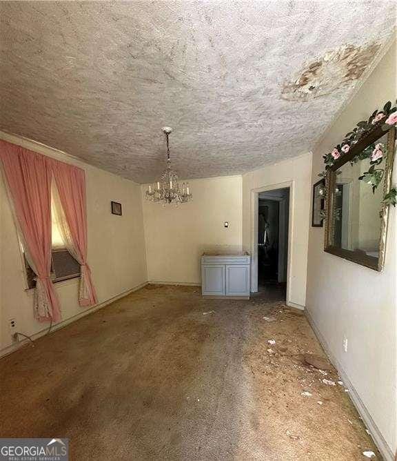 770 E Park Ave, Savannah, GA 31401 - unfurnished dining area featuring a textured ceiling, a chandelier, and baseboards