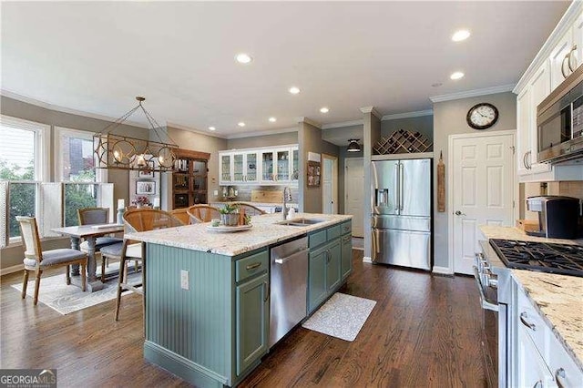 kitchen featuring appliances with stainless steel finishes, a sink, white cabinets, a kitchen island with sink, and recessed lighting