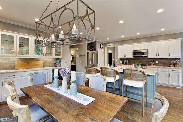dining room featuring ornamental molding, a chandelier, recessed lighting, and wood finished floors