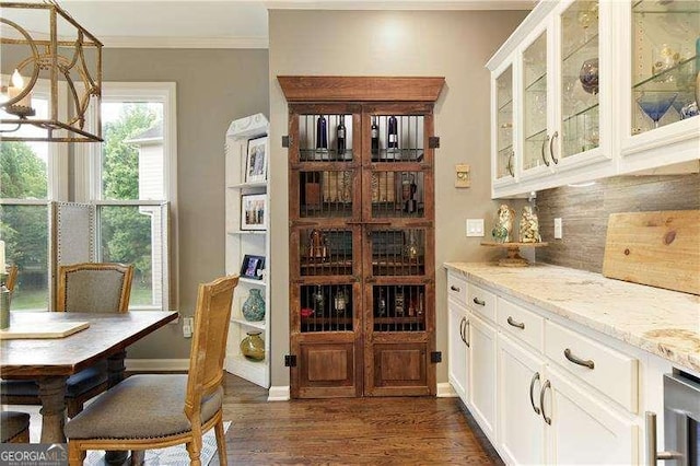 bar featuring ornamental molding, dark wood finished floors, decorative backsplash, wine cooler, and a chandelier