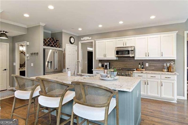 kitchen with stainless steel appliances, a sink, white cabinetry, tasteful backsplash, and recessed lighting