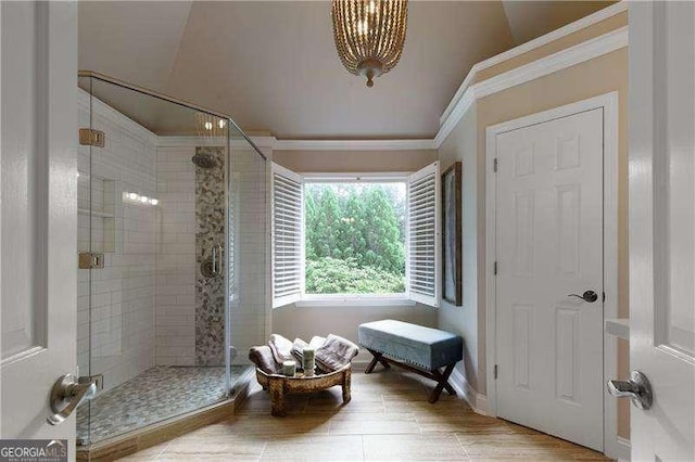bathroom featuring crown molding, a shower stall, baseboards, and wood finished floors