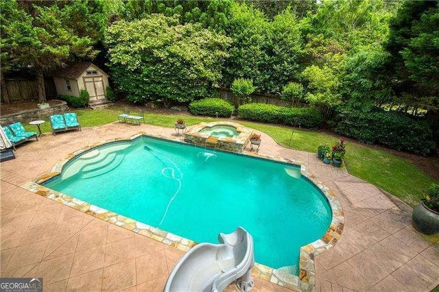 view of pool with a patio, a shed, fence, an in-ground hot tub, and an outdoor structure