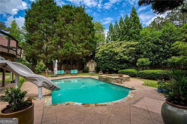 view of swimming pool with a storage shed, a patio area, an outdoor structure, and a fenced backyard