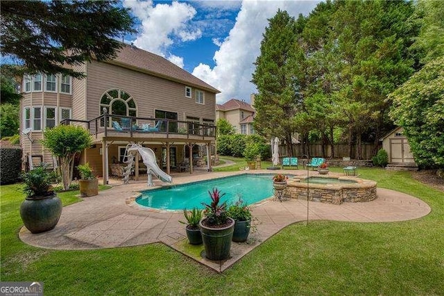 view of swimming pool featuring a patio, a shed, a water slide, an outbuilding, and a wooden deck
