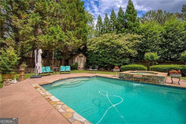 view of swimming pool featuring an in-ground hot tub, a storage shed, a fenced backyard, and an outdoor structure