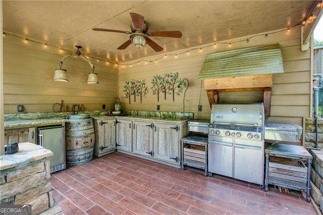 view of patio with exterior kitchen, ceiling fan, and a grill