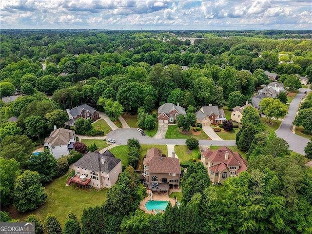 aerial view of residential area with a forest and a pool